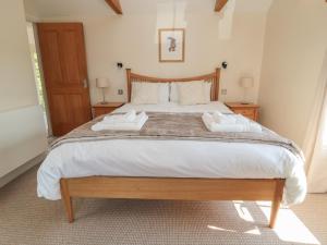 a bedroom with a large bed with two towels on it at Dereside in Hexham