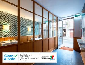 a bathroom with two sinks and glass walls at Pensao O Laranjeira in Viana do Castelo