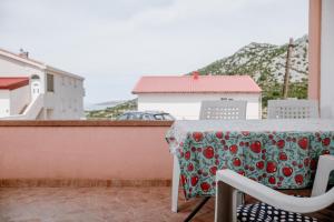 Apartmens Leona في كارلوباغ: طاولة مع قطعة قماش زهرة على الشرفة