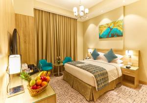 - une chambre d'hôtel avec un lit et une corbeille de fruits dans l'établissement Rose Plaza Hotel Al Barsha, à Dubaï