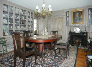 a dining room with a table and chairs and a fireplace at 29 India House in Nantucket