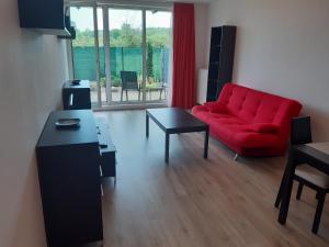 a living room with a red couch and a table at Apartment Park Radouč - 60m2 in Mladá Boleslav