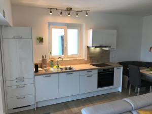 a kitchen with white cabinets and a sink at Apartment Nona Ervina in Koper