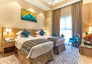 a hotel room with two beds and a window at Rose Plaza Hotel Al Barsha in Dubai