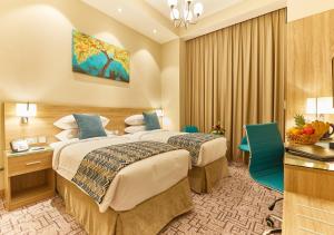 a hotel room with two beds and a desk at Rose Plaza Hotel Al Barsha in Dubai +59 photos