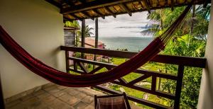 a hammock in a room with a view of the ocean at Pousada Marajoara - Pipa in Pipa