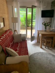 a living room with a couch and a sliding glass door at les Cimes d'Or Mont blanc in Les Contamines-Montjoie