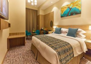 Habitación de hotel con cama y escritorio en Rose Plaza Hotel Al Barsha en Dubái