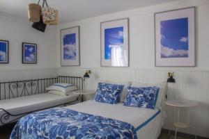 a bedroom with a bed and a bench in it at Vinnus Guesthouse in Ericeira