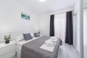 Un pat sau paturi într-o cameră la Apartments Deluxe Vučko