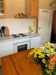 una cocina con una mesa con un jarrón de flores en Ferienwohnung Frühlingsau en Freudenstadt