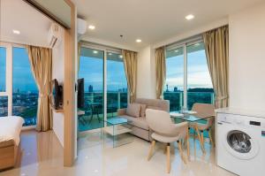 a living room with a couch and a table at Rare Panoramic Sea, City & Mountain Views - XXL Balcony - Free Fast WIFI - Pool - City Garden Tower 2317 in Pattaya South
