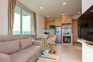 a living room with a couch and a table at Rare Panoramic Sea, City & Mountain Views - XXL Balcony - Free Fast WIFI - Pool - City Garden Tower 2317 in Pattaya South