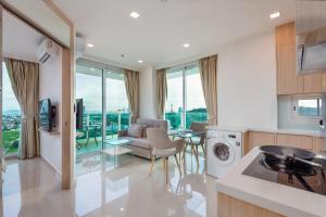 a kitchen and living room with a couch and a table at Rare Panoramic Sea, City & Mountain Views - XXL Balcony - Free Fast WIFI - Pool - City Garden Tower 2317 in Pattaya South
