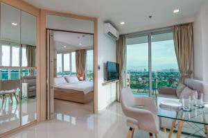 
a hotel room with a large window overlooking the ocean at Sea View - 270 Degree Panorama Views High Floor Balcony - Central - Free WIFI - Full Kitchen in Pattaya South

