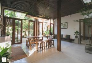 a dining room with a table and chairs at Forest Tag Homestay in Hue