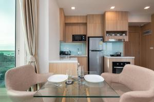
a kitchen with a table and chairs and a refrigerator at Sea View - 270 Degree Panorama Views High Floor Balcony - Central - Free WIFI - Full Kitchen in Pattaya South

