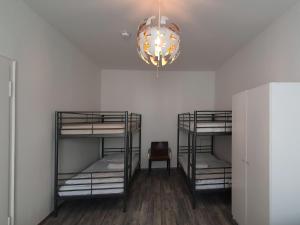 a room with three bunk beds and a chandelier at Aparthouse Graf-Adolf in Düsseldorf