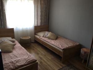sypialnia z dwoma łóżkami i oknem w obiekcie Apartament Ełk Promenada w mieście Ełk