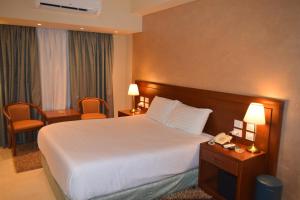 a hotel room with a bed and a telephone at Omar El Khayam Al Minya Hotel - Luxury Accommodation in Minya +32 photos
