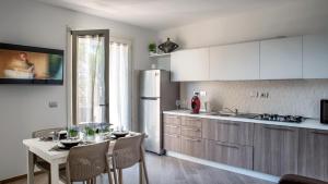 a kitchen with a table and a white refrigerator at Marco's House in Alghero