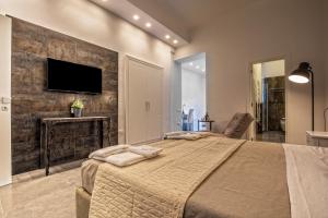 a bedroom with a large bed and a tv on a wall at Materia relais in Cava deʼ Tirreni