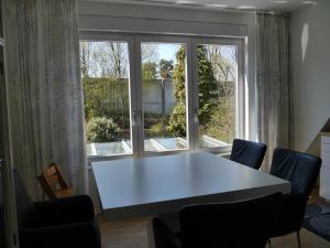 FeWo BlumenPott في دورتموند: طاولة بيضاء وكراسي أمام النافذة