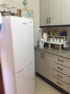 a kitchen with a white refrigerator in a kitchen at Maribella in Badolatosa