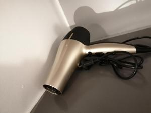 a hair dryer is attached to a wall at La tête dans les nuages - Chez Léa in Braine-lʼAlleud +13 photos