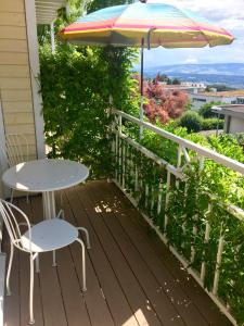 une table et des chaises sur une terrasse avec un parasol dans l'établissement Zimmer mit Bad und Balkon, à Widen