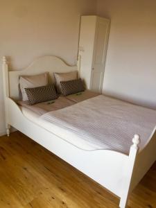 - un grand lit blanc avec 2 oreillers dans l'établissement Zimmer mit Bad und Balkon, à Widen