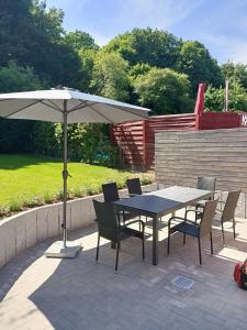 einen Tisch und Stühle mit Sonnenschirm auf einer Terrasse in der Unterkunft Ferienwohnungen Arp - Haus Inge in Eckernförde