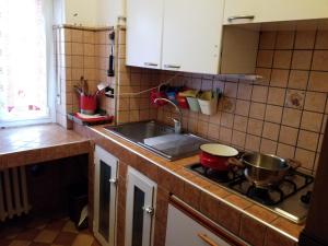 uma cozinha com um lavatório e uma panela no fogão em Cara Revello em Milão