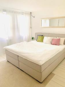 - un grand lit blanc avec quatre oreillers dans une chambre dans l'établissement Altstadtdomizil Schwäbisch Hall, à Schwäbisch Hall