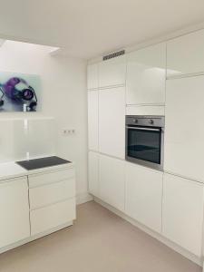 a white kitchen with white cabinets and a stove at Altstadtdomizil Schwäbisch Hall in Schwäbisch Hall