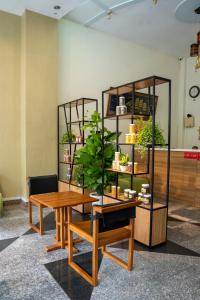 ein Zimmer mit einem Tisch und einem Regal mit Pflanzen in der Unterkunft Aqua Kim Long Hotel in Ho-Chi-Minh-Stadt