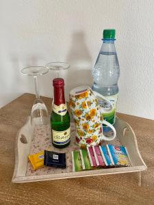a tray with a bottle of wine and a glass at Steigerwaldblick Apartments Burgebrach in Burgebrach