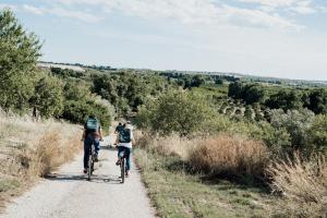 two people riding bikes down a dirt road at I Carusi Relais in Noto