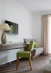 une chaise verte dans une chambre avec un lit dans l'établissement Gasthof-Pension Schütz, à Wesenufer