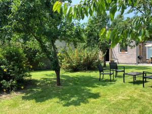 a picnic table and chairs under a tree in a yard at La maison d'Olivier in Honfleur