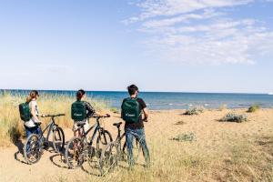 three men standing with their bikes on the beach at I Carusi Relais in Noto