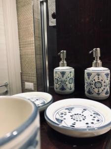 uma casa de banho com 2 lavatórios azuis e brancos e um espelho em Classic Home em Castelbuono