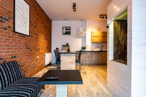 a living room with a brick wall and a table at Willa Zdrojowa in Polańczyk