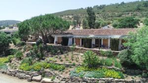 una casa con jardín frente a una montaña en Monte Da Vilarinha, en Carrapateira