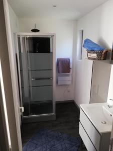 a bathroom with a glass shower and a sink at La Houle, maison classée 4 étoiles in Criel-sur-Mer