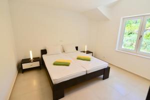 a bedroom with a bed with two towels on it at Apartments Petrovac in Zavala