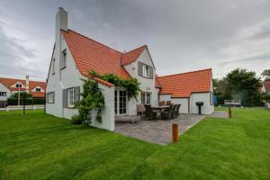 een huis met een patio en een grasveld bij Niels in Nieuwpoort