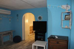 a living room with a tv and a blue wall at Ellysblue Guesthouse in Pizzo