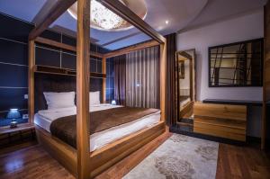 a bedroom with a canopy bed and a mirror at Bentley Apartments in Pristina