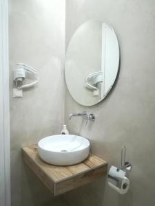 a bathroom with a white sink and a mirror at Loginos Studios in Kallithea Halkidikis